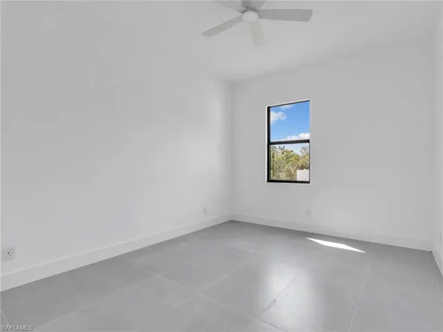 Unfurnished room featuring light tile patterned floors and ceiling fan