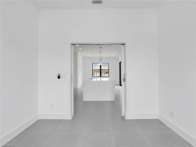 Spare room featuring baseboards and dark tile patterned flooring