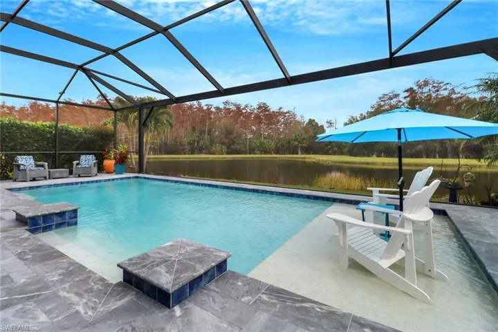 View of pool with a patio, a water view, and a lanai