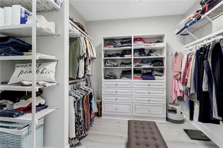 Walk in closet with light wood-type flooring