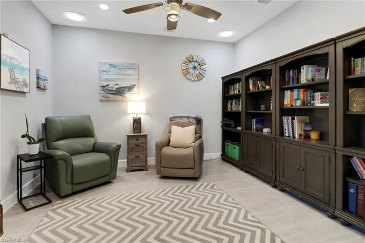 Living area featuring ceiling fan and light tile patterned floors