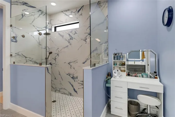 Bathroom with vanity and tiled shower