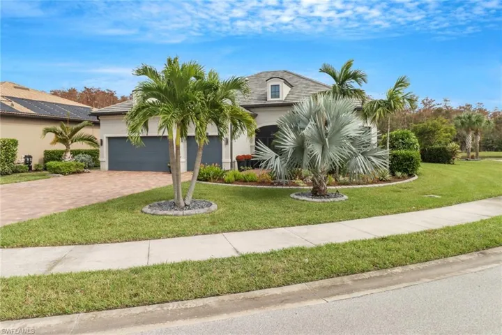 View of front of house with a front yard and a garage