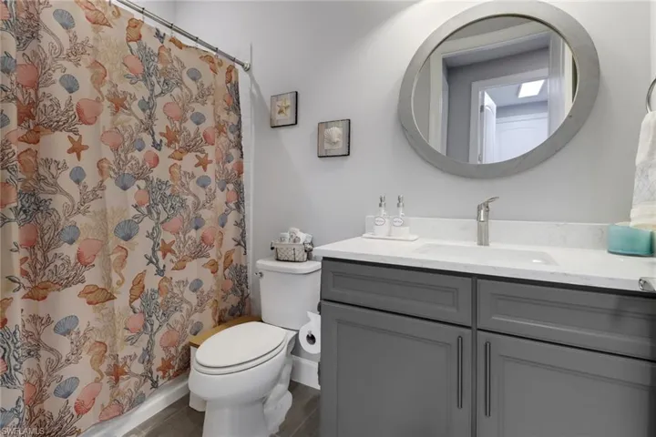 Bathroom with toilet, hardwood / wood-style flooring, vanity, and a shower with shower curtain