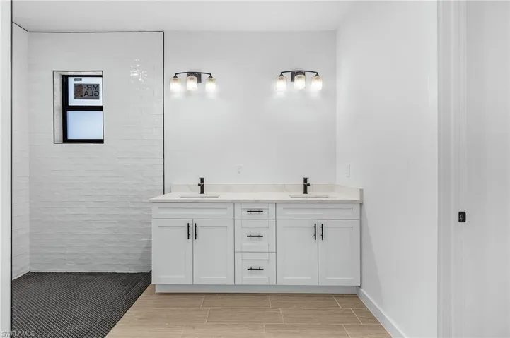 Bathroom with vanity and tiled shower
