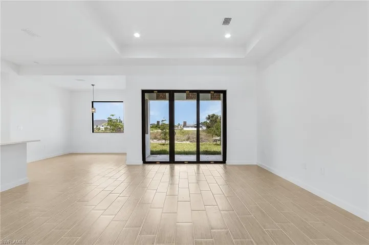 Unfurnished room featuring light hardwood / wood-style flooring and a tray ceiling