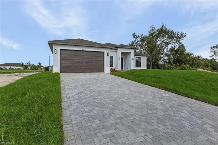 View of front of home featuring a garage and a front lawn