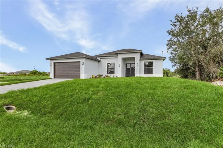 View of front of home with a front lawn and a garage
