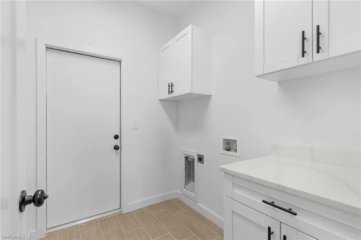 Laundry room featuring hookup for a washing machine, cabinets, light wood-type flooring, and electric dryer hookup