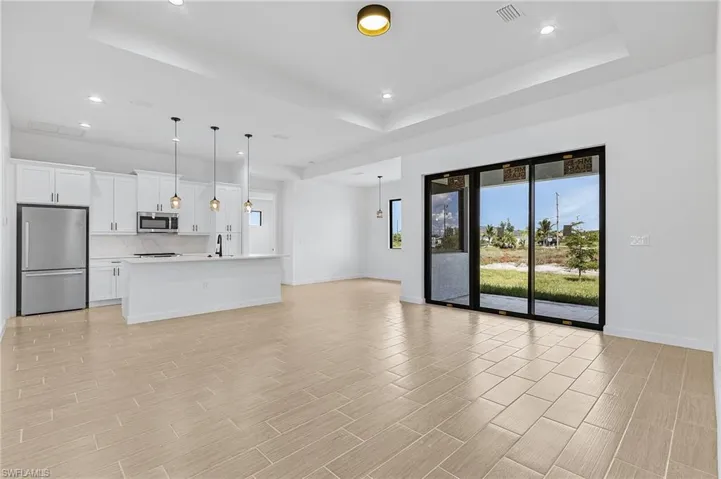 Unfurnished living room with a tray ceiling and sink