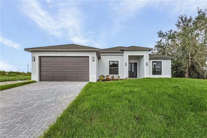 Prairie-style home featuring a front lawn and a garage