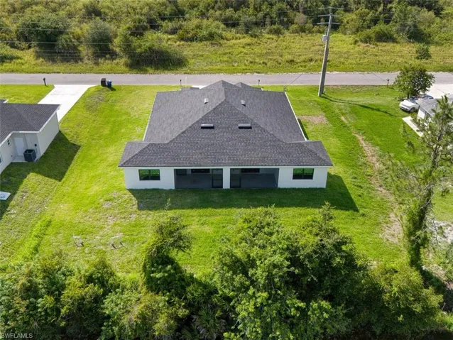 Newly constructed residence featuring a dark shingle roof and white exterior