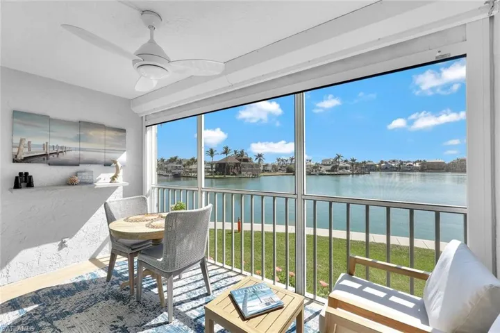 Sunroom featuring a water view and ceiling fan