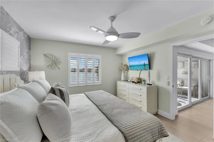 Bedroom with ceiling fan, access to outside, and light hardwood / wood-style floors