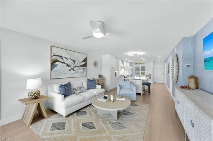 Living room with ceiling fan and light hardwood / wood-style floors