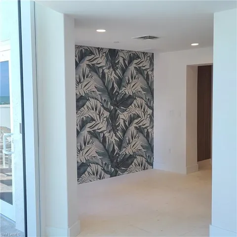 Hallway to elevators, an accent wall, baseboards, and recessed lighting