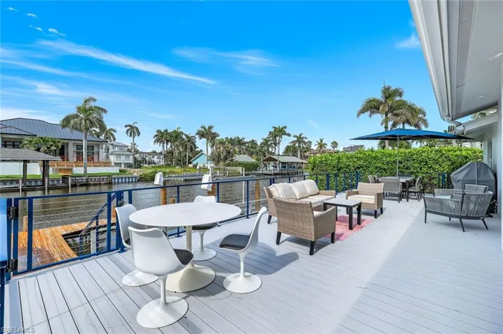 Deck with an outdoor living space, a water view, a residential view, and grilling area