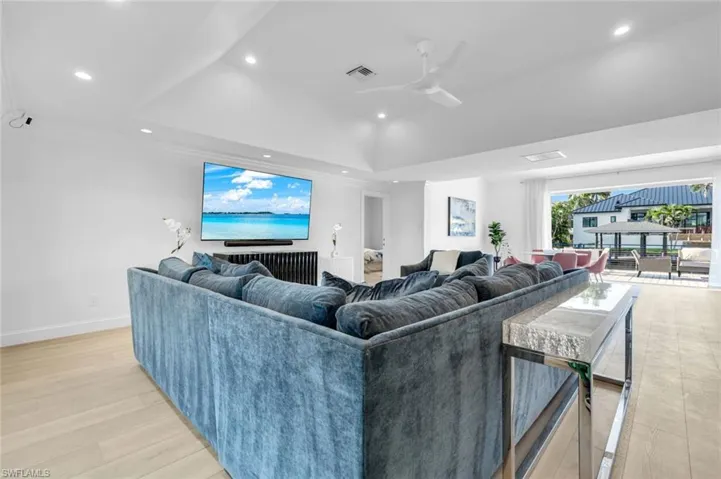 Living area featuring a tray ceiling, recessed lighting, and a ceiling fan