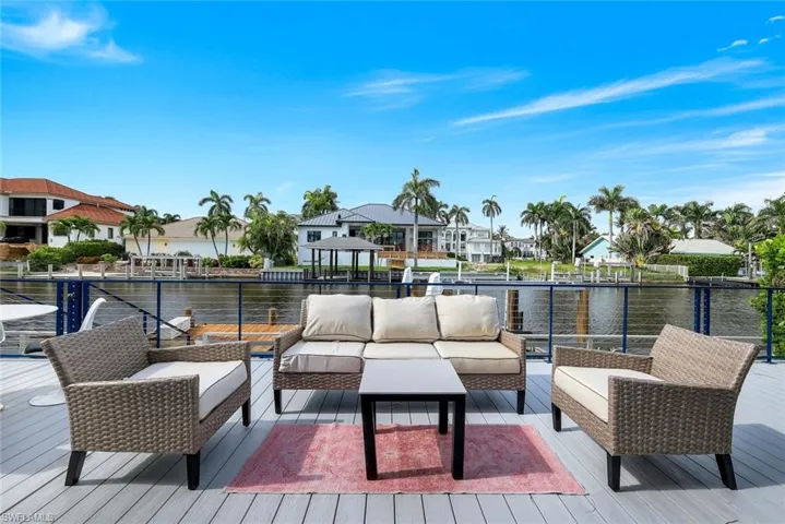 Wooden terrace with a residential view, a water view, and an outdoor hangout area