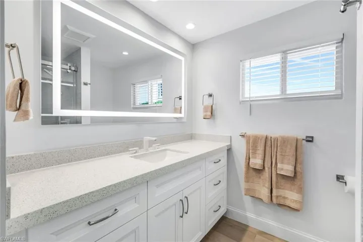Bathroom featuring vanity, a stall shower, recessed lighting, and light wood-style flooring