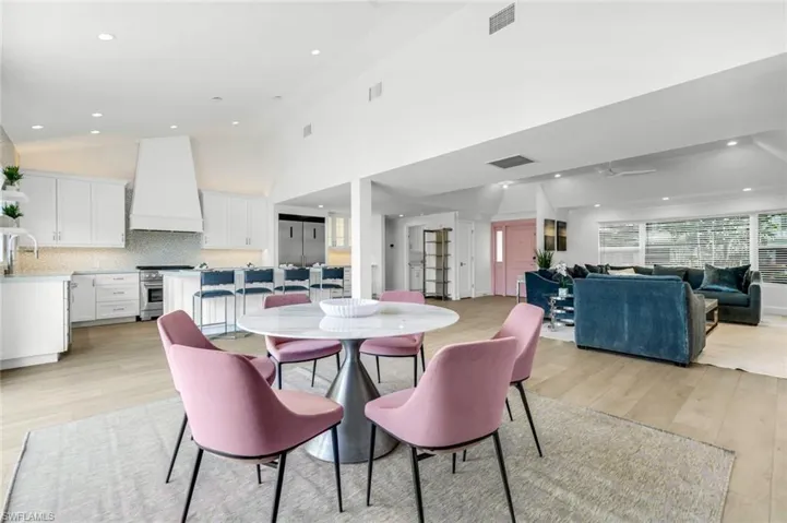 Dining room featuring light wood finished floors, recessed lighting, ceiling fan, and a high ceiling