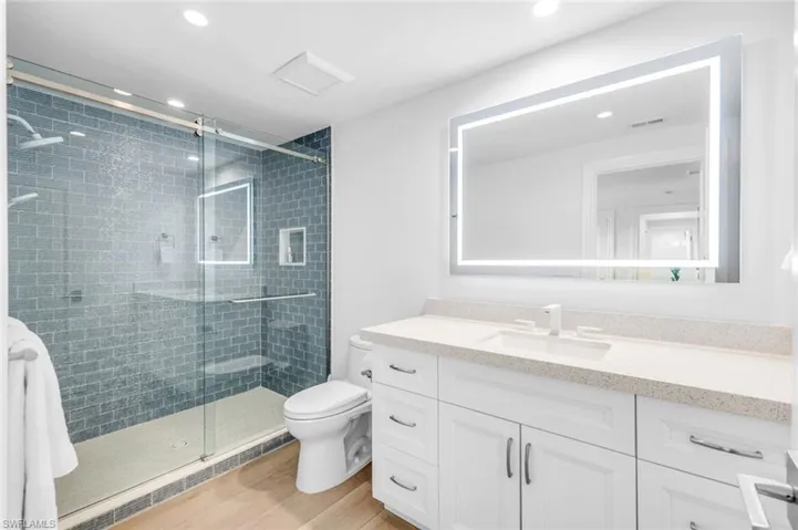 Bathroom with vanity, a shower stall, light wood-style floors, and recessed lighting