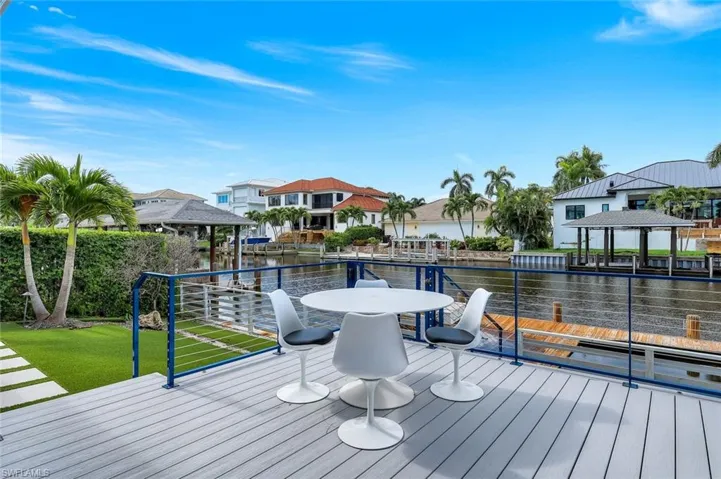Dock with a gazebo, a residential view, a lawn, and a deck with water view