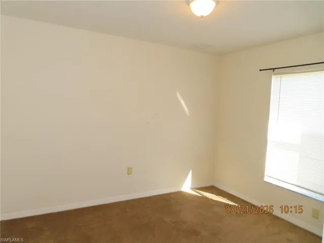 Empty room featuring carpet flooring and baseboards