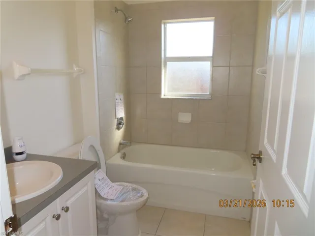 Bathroom featuring vanity, light tile patterned floors, and tub / shower combination