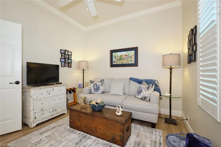 Living room with crown molding, ceiling fan, and hardwood / wood-style flooring
