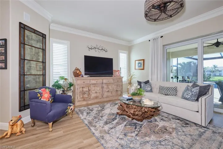 Living room with crown molding, plenty of natural light, and light hardwood / wood-style floors