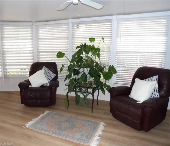 Sitting room with wood finished floors, a ceiling fan, and plenty of natural light