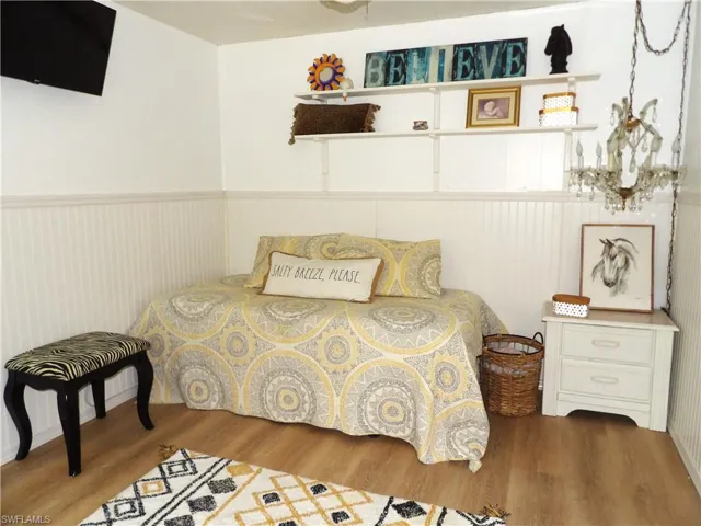 Bedroom with wood finished floors and wainscoting