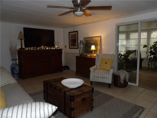 Living area featuring light tile patterned floors and a ceiling fan
