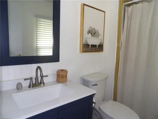 Bathroom with curtained shower and vanity