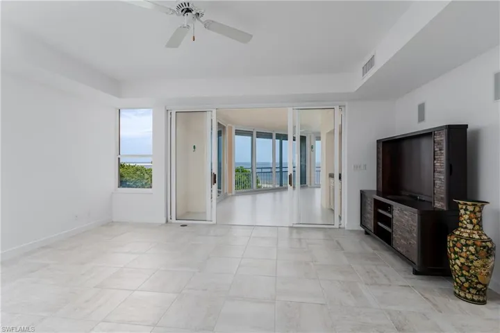Unfurnished living room with ceiling fan and light tile patterned flooring