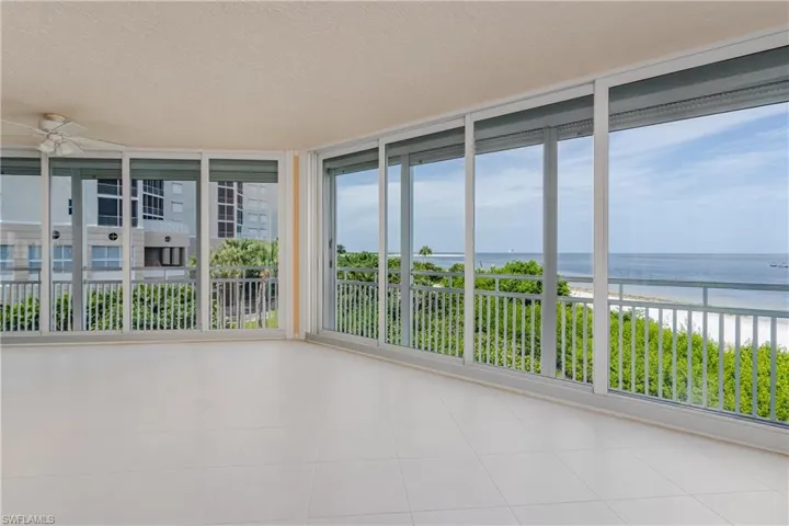 Unfurnished sunroom featuring ceiling fan and a water view