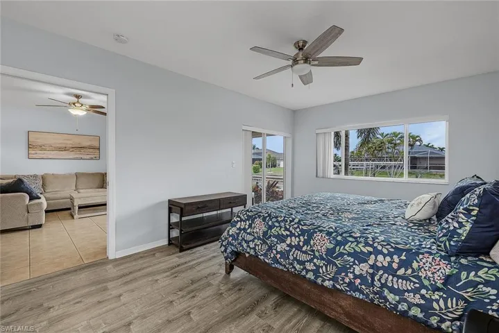 Bedroom featuring access to outside, a ceiling fan, and wood finished floors