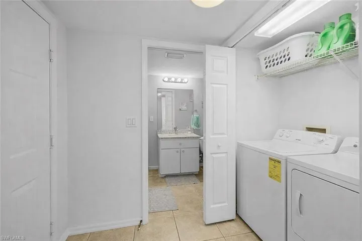 Laundry room featuring washing machine and dryer and light tile patterned floors