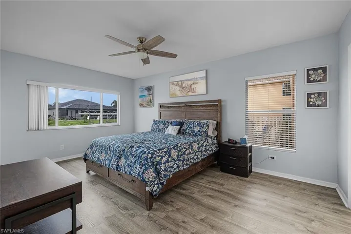 Bedroom with multiple windows, ceiling fan, and wood finished floors