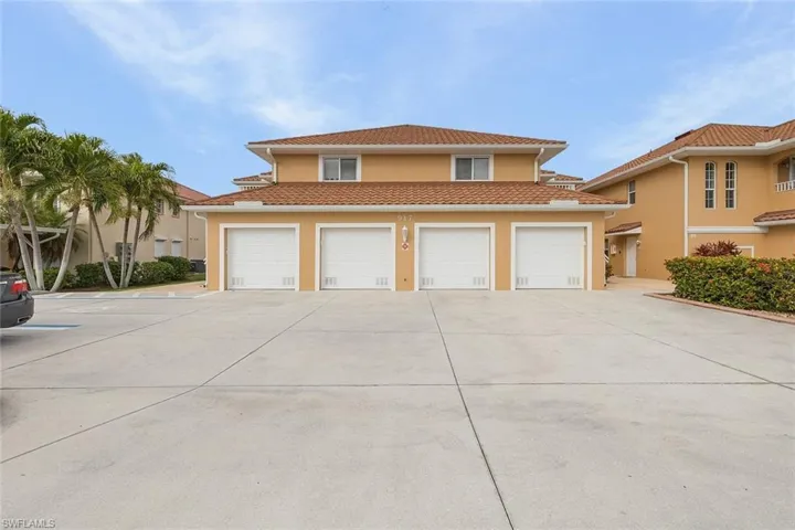 View of front of house with stucco siding, a tile roof, concrete driveway, and a garage