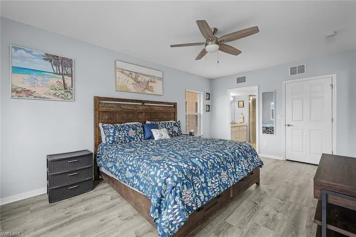 Bedroom featuring connected bathroom, wood finished floors, and a ceiling fan