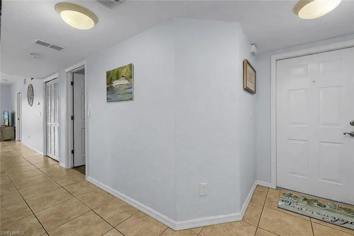 Hall featuring light tile patterned flooring and baseboards