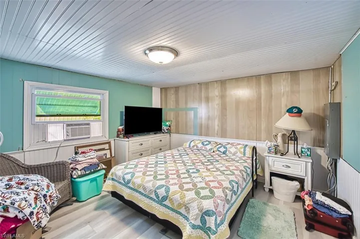 Bedroom featuring wood walls and wood finished floors