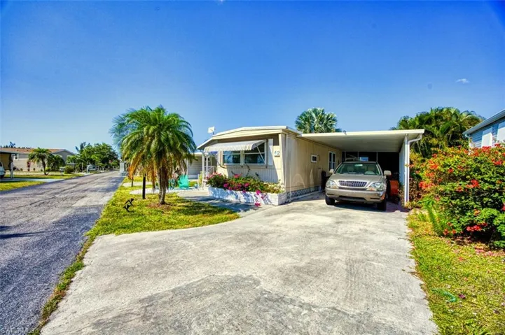 View of front facade with concrete driveway and an attached carport