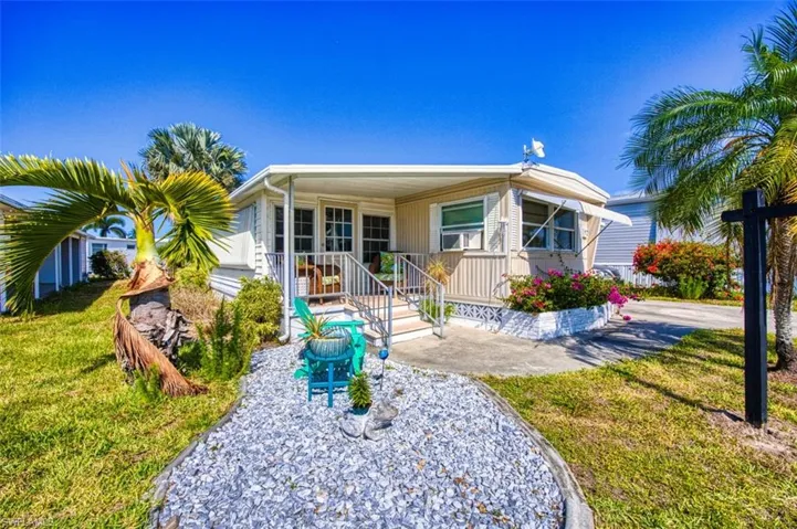 Manufactured / mobile home featuring a porch and a front lawn