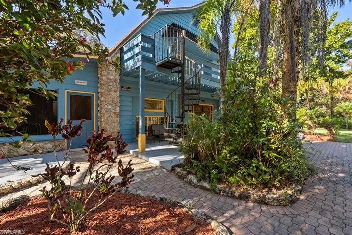 Back of property featuring a balcony and stairway