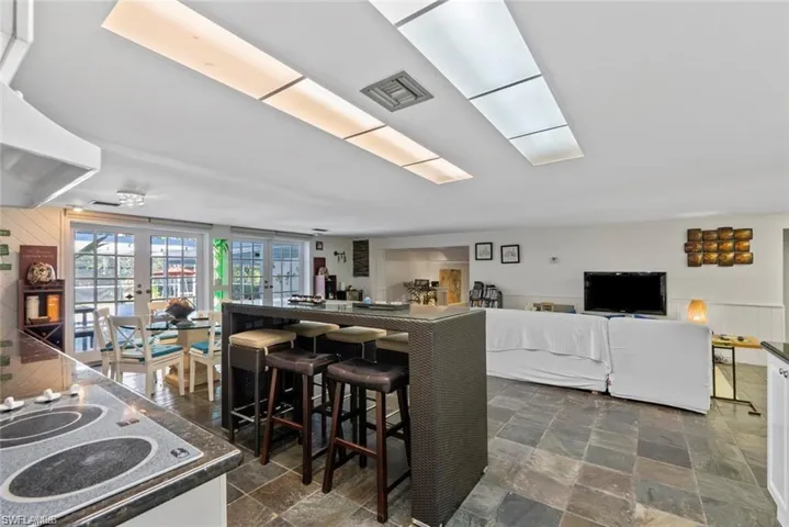 Kitchen featuring electric stovetop, dark stone finish flooring, french doors, and dark countertops