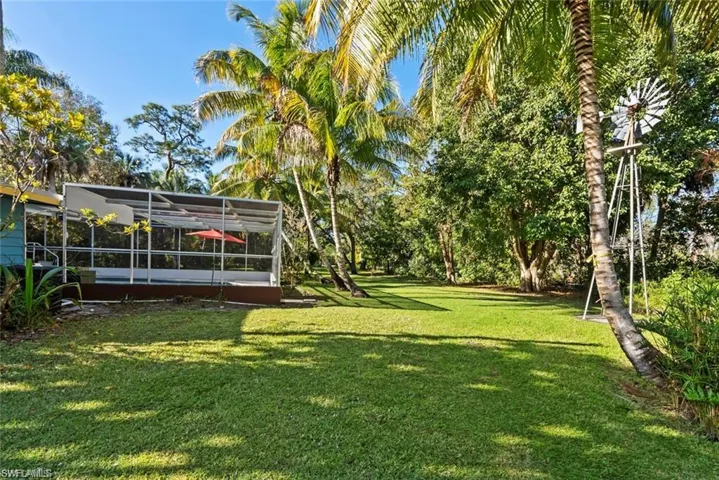View of grassy yard featuring a sunroom