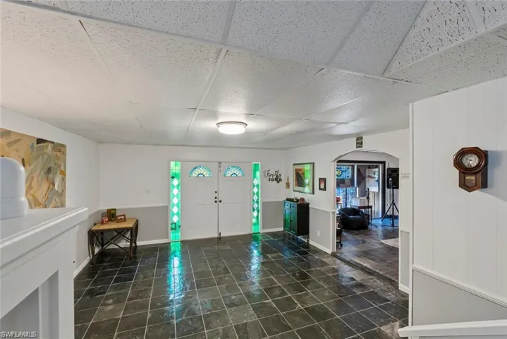 Entryway featuring arched walkways and a paneled ceiling
